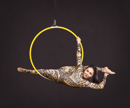 118678661-a-young-girl-in-a-suit-with-a-print-performs-acrobatic-elements-in-the-air-ring-studio-shooting-perf.jpg